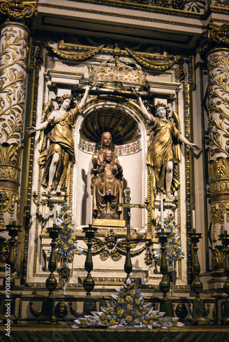 Shining gold sculpture of Blessed Virgin Mary inside a historic catholic cathedral