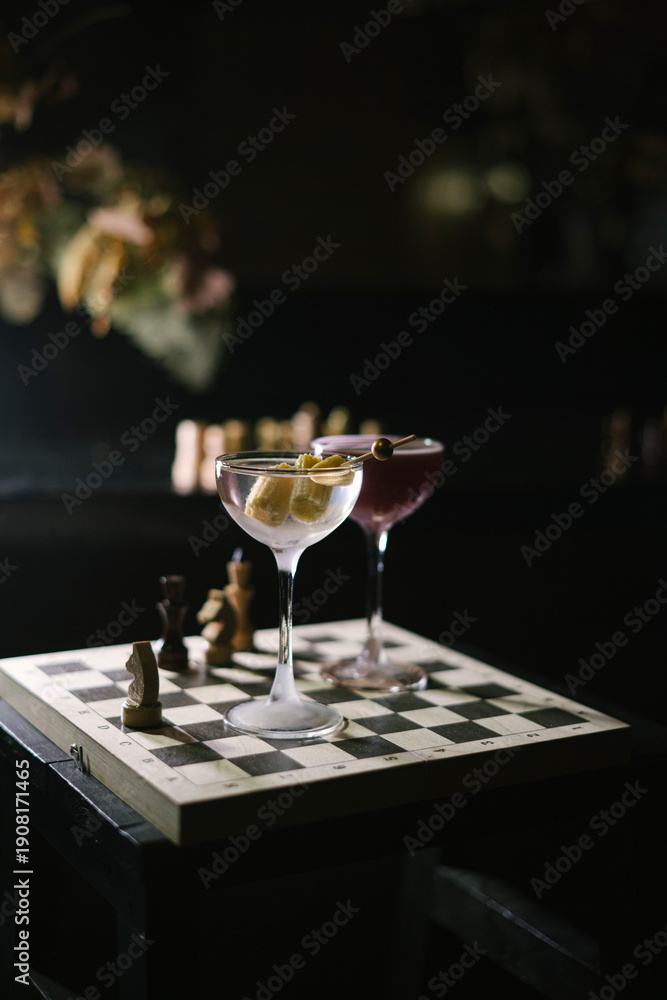 custom made wallpaper toronto digitalOne dirty martini and a twist on espresso martini, standing on a wooden chess board in the dark room, close up view 