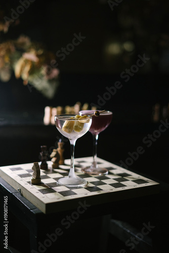 Wallpaper Mural One dirty martini and a twist on espresso martini, standing on a wooden chess board in the dark room, close up view  Torontodigital.ca