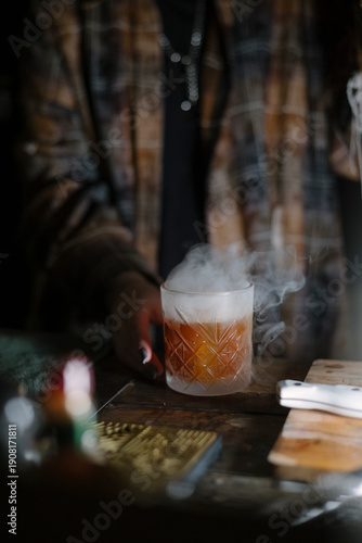 Wallpaper Mural Female bartender standing by the bar counter, making a cocktail, smoking the glass, close up vertical image Torontodigital.ca