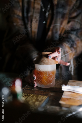Wallpaper Mural Female bartender standing by the bar counter, making a cocktail, smoking the glass, close up vertical image Torontodigital.ca