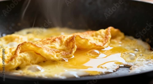 Fluffy omelette with runny egg yolk frying in pan close-up
