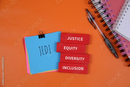 Schilderij op canvas blue Jedi notebook and red blocks reading Justice, Equity, Diversity, and Inclusion, symbolizing diversity and inclusive teamwork in education and work environments