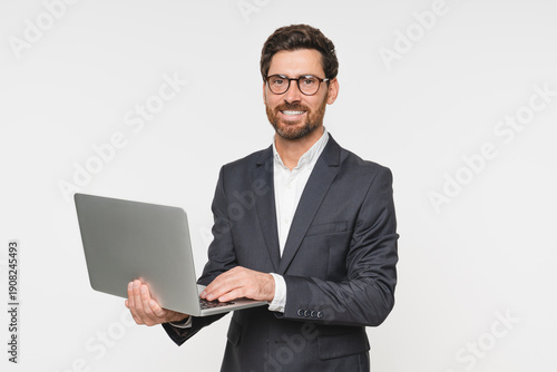 Busy business man using laptop standing isolated on white background. Male professional businessman ceo executive wearing suit holding computer working online checking corporate results.