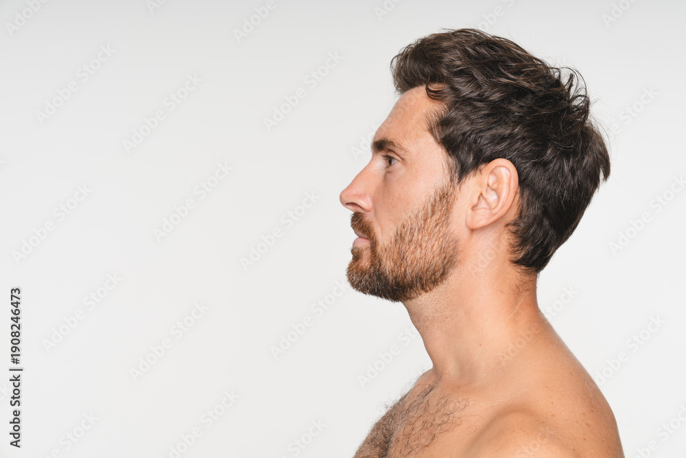 Obraz premium Close-up of a man's profile, focusing on his ear, jawline, and neck against white studio background. Facial features. Concept of beauty, care, cosmetology treatment, wellness, masculinity. Copy space
