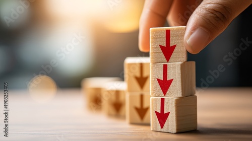 cube with cost and red downward arrow placed on table with hand showing concept of economic recession and inflation control with copy space economic recession, inflation control, profit improvement, 