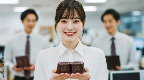 Smiling woman presenting chocolate in office setting