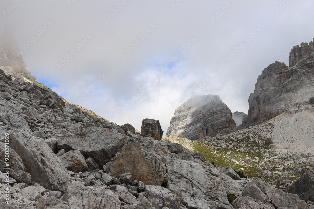 Fototapeta premium Cloud‑covered Dolomites peaks rising above Rifugio Lavaredo in dramatic alpine scenery
