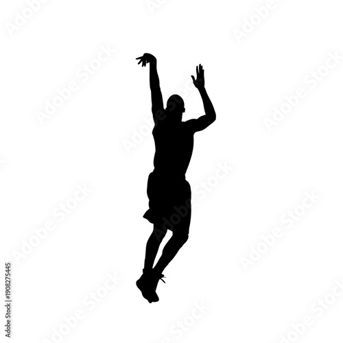 Silhouette of a basketball player shooting the ball during a game.