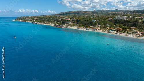 Wallpaper Mural Aerial view of a vibrant blue coastline. The deep azure sea meets a white sandy shore lined with lush green hills, coastal villages. It's Tono Beach, located in Calabria in the coast of Gods, Italy. Torontodigital.ca