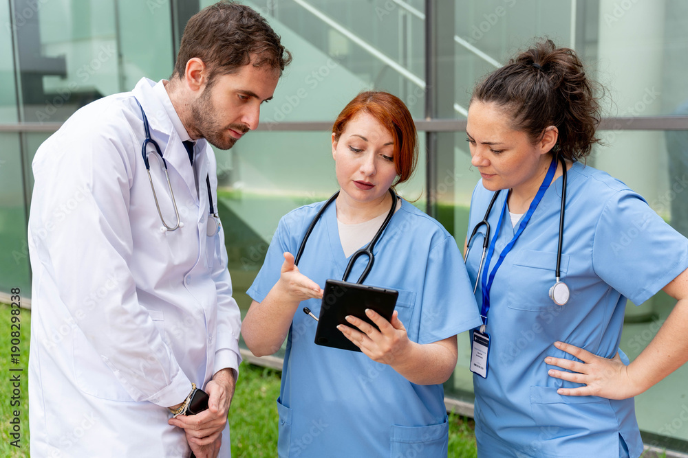 © StockMe - Medical team collaborating outdoors, using a digital tablet for healthcare data analysis and patient discussion