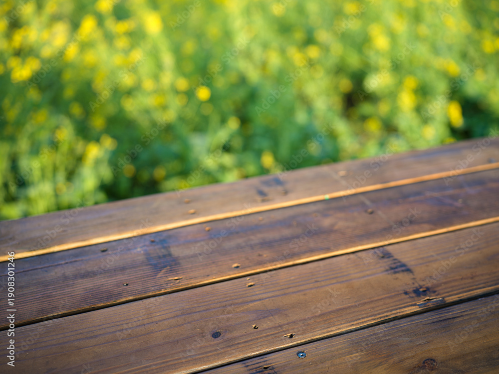 Fototapeta premium Wooden Table Amid Yellow Flowers
