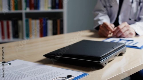 A desk with a blue clip on it and a stack of books behind it. The clip is holding a piece of paper, which is likely a contract or some other important document