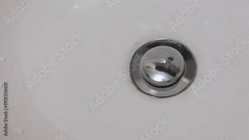 Wallpaper Mural Finger pressing a pop-up sink drain stopper creating a mechanical click and gurgling water sound Torontodigital.ca