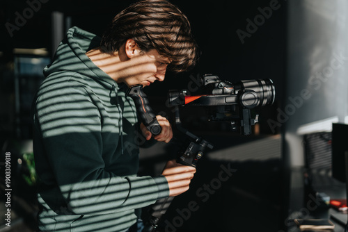 Fotografia A filmmaker in a green hoodie tunes a gimbal for a steady video shot