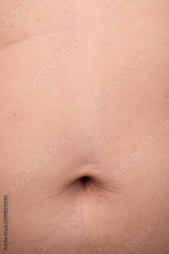 Vertical close up image of the navel of an adult male. Copy space for text. For graphic design, 3D rendering and banners
