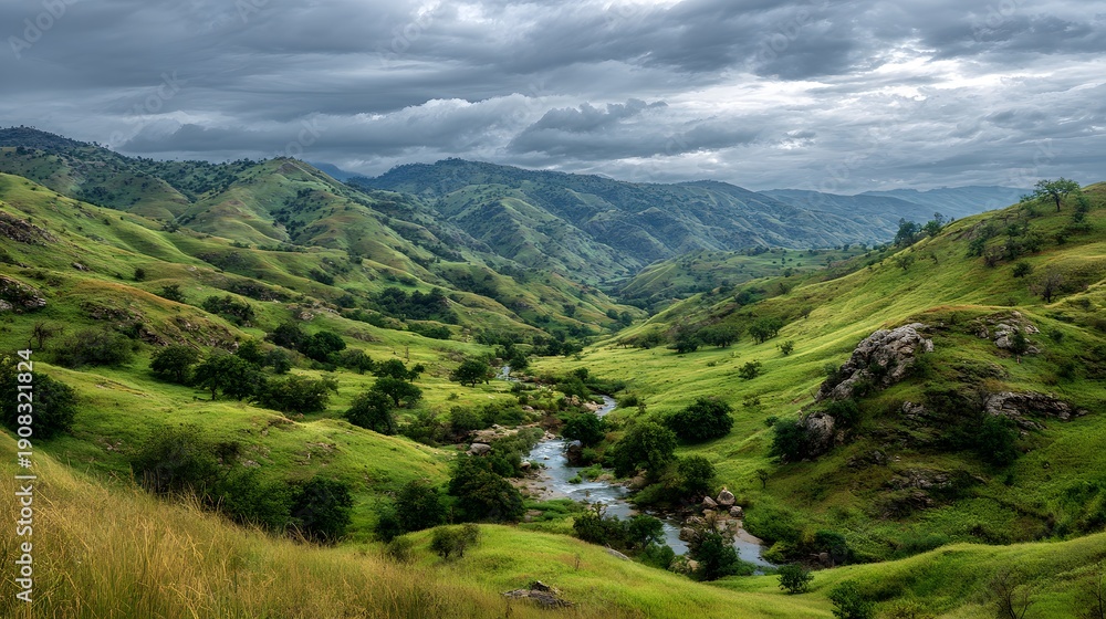 Obraz premium Lush Green Rolling Hills Under Dramatic Cloudy Sky.