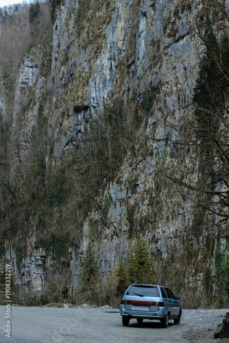 The station wagon is parked in a ravine among the mountains