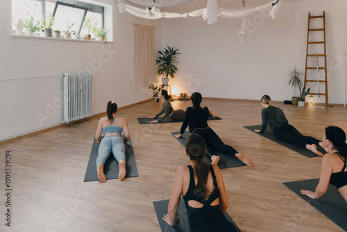 Small group practicing cobra pose in yoga class focusing on mindfulness