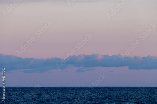 Minimal ocean horizon at pastel sunrise with calm sea