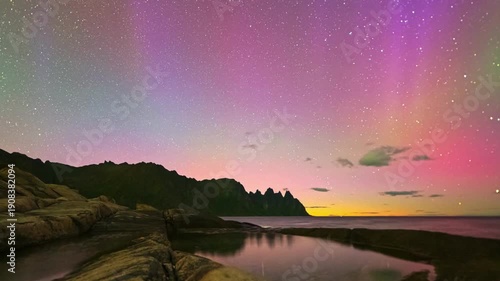 Scenic color with green and purple northern lights over a dark winter horizon. amazing events of Universe