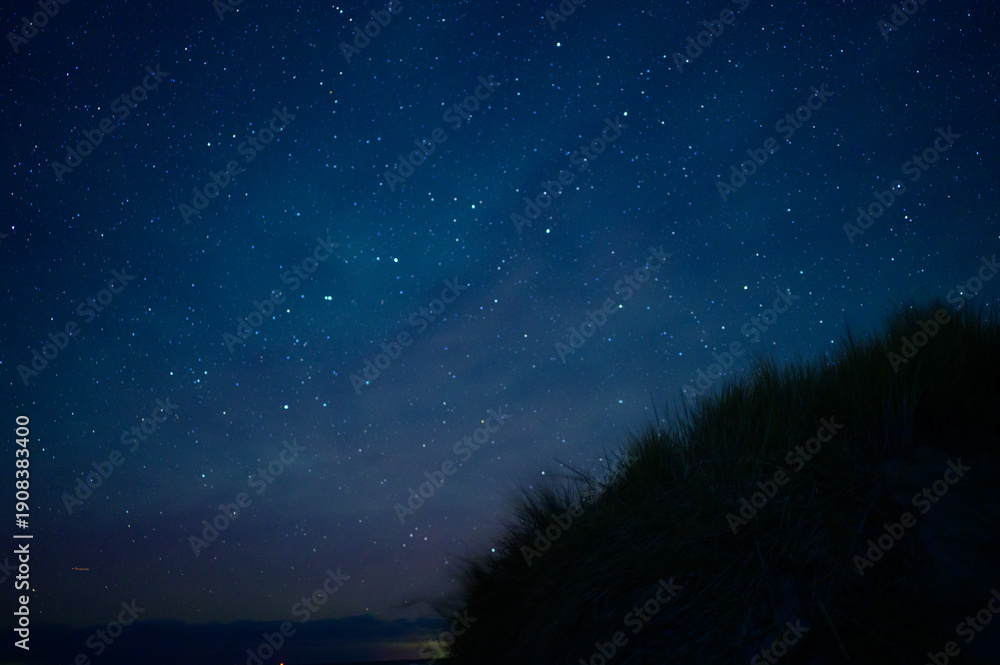 Fototapeta premium Sternenhimmel über Dünenlandschaft – klare Nacht mit funkelnden Sternen