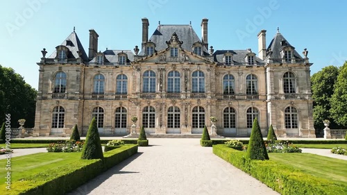 Ornate French chateau facade with formal garden and topiary. Historic stone palace architecture in Europe. Luxury estate and heritage tourism
