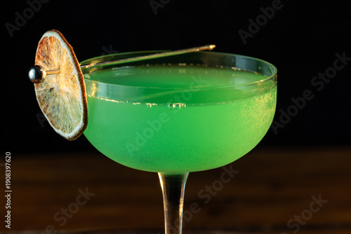 classic green drink with vibrant color on a wooden tray with harsh dramatic lighting