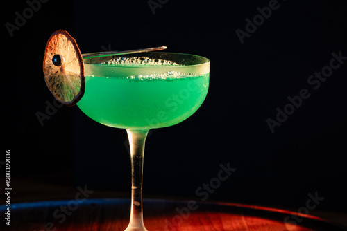classic green drink with vibrant color on a wooden tray with harsh dramatic lighting