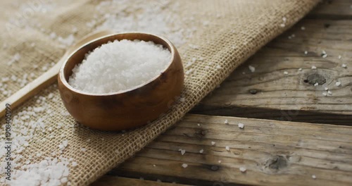 Video of salt in a bowl and spoon on wooden background
