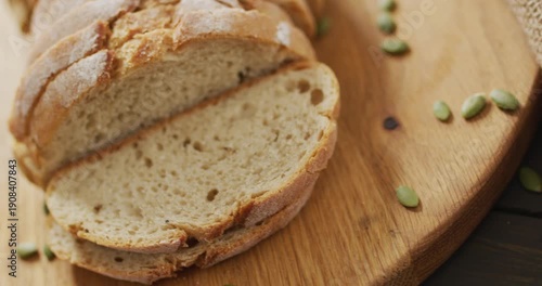 Video of bread on chopping wooden board on wooden worktop