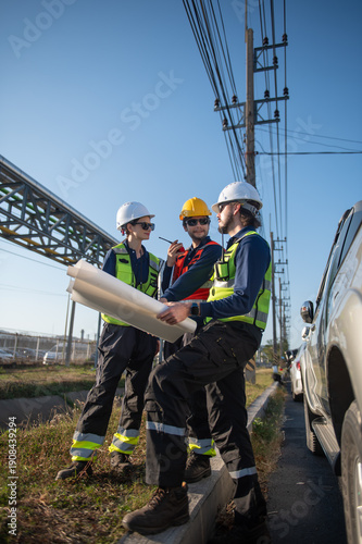 Engineers Reviewing Construction Plans at Industrial Gas Storage Facility, Industrial engineer inspecting petrochemical facility construction blueprint at gas storage plant site.