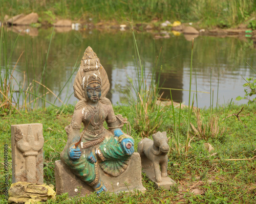 Valokuva Damaged statue of a woman deity near a river bank in Tamil Nadu kodiveri dam