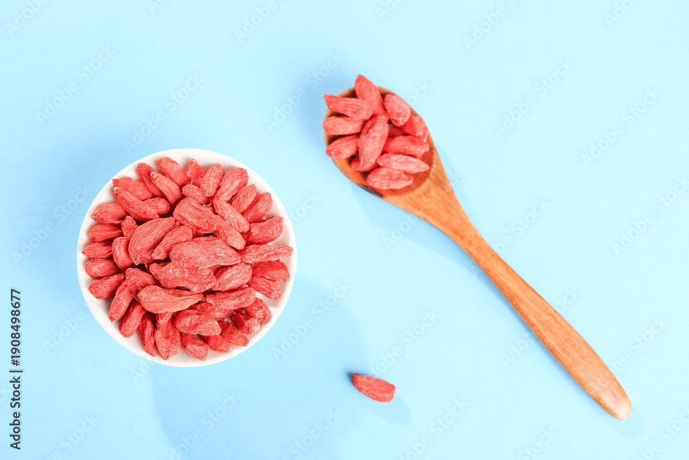 Fototapeta premium Dried Red Goji Berries from Ningxia in Bowl and Wooden Spoon Still Life Food Photography