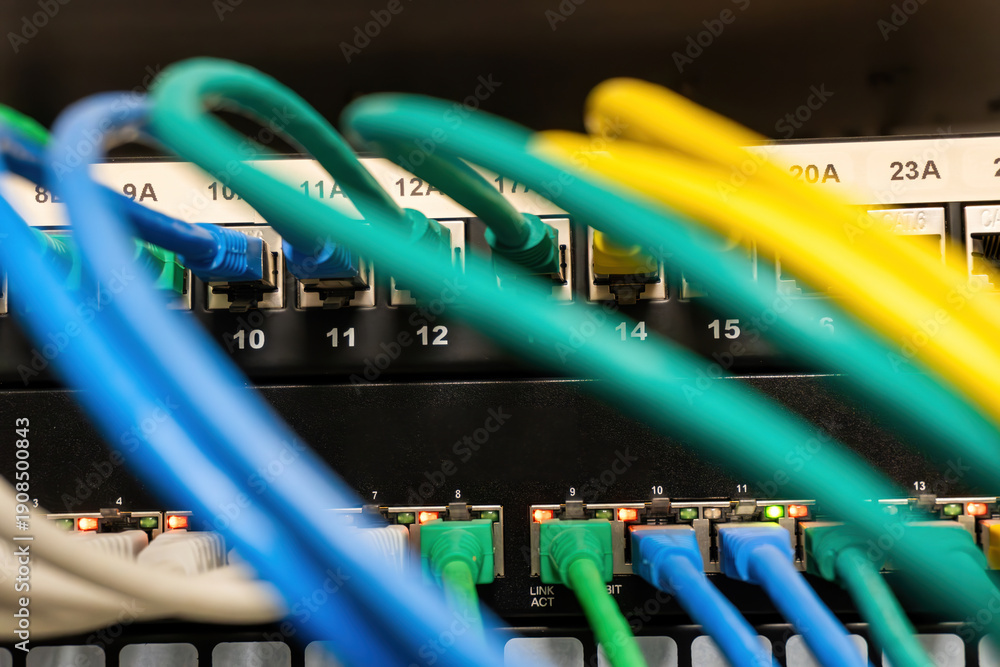 Фотография Colorful ethernet cables plugging into network switch ports with blinking indica