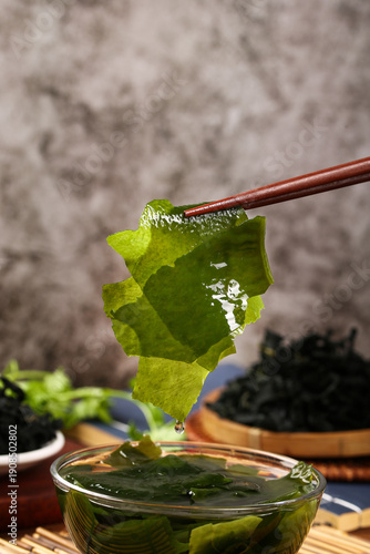 Fotografía Fresh Wakame Seaweed with Chopsticks - Traditional Asian Kelp Preparation for He