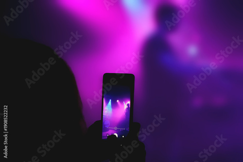 A girl records her favorite band's performance on her cell phone