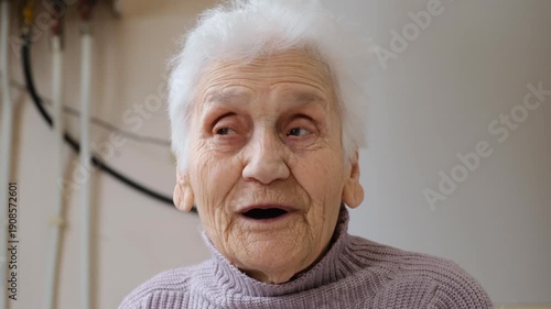 Sweet elderly woman speaking positively and instructively, gray-haired grandmother telling an interesting story. Happy aging, social interaction, and elderly care concept.