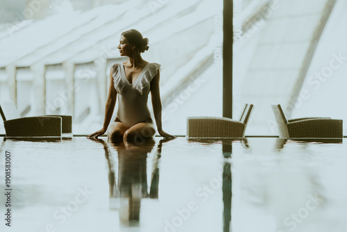 Woman sits by the water in ...