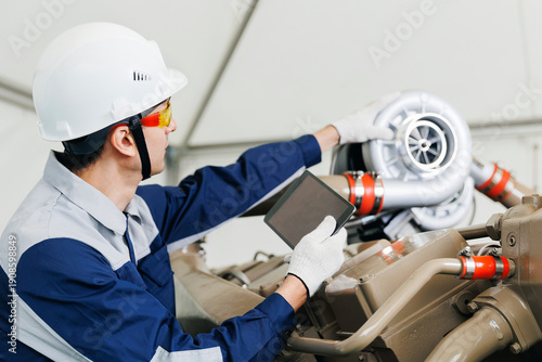 Canvastavla Mechanic with tablet computer performs diagnostics on turbocharged engines of mi