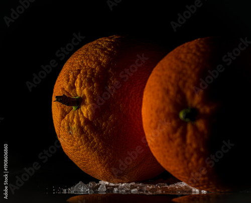 Orange fruit detail with shiny black table and white salt