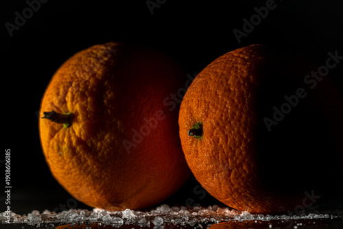 Orange fruit detail with shiny black table and white salt