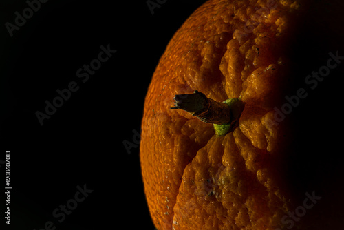 Orange fruit detail with shiny black table and white salt
