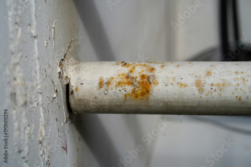 Close-up of rusty metal pipe with peeling paint and corrosion damage