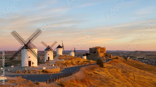 Golden sunrise timelapse over the historic windmills and castle of Consuegra in La Mancha, Spain