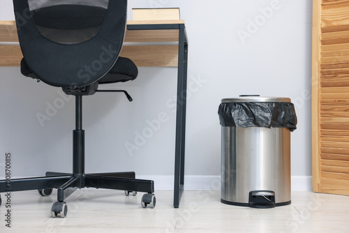 Quadro su tela Metal trash bin with plastic bag on floor indoors