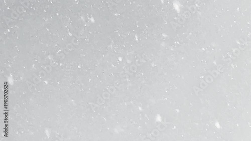 Heavy snowfall with thick snow falling outdoors. Winter weather with large snowflakes filling the air, creating a blurry bokeh effect and cozy dramatic mood.