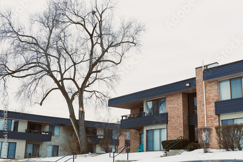 Foto Winter view of apartment buildings with bare trees in a residential area during