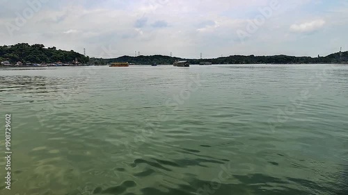 view of a green lake with a background of mountains and blue sky