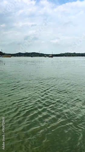 view of a green lake with a background of mountains and blue sky